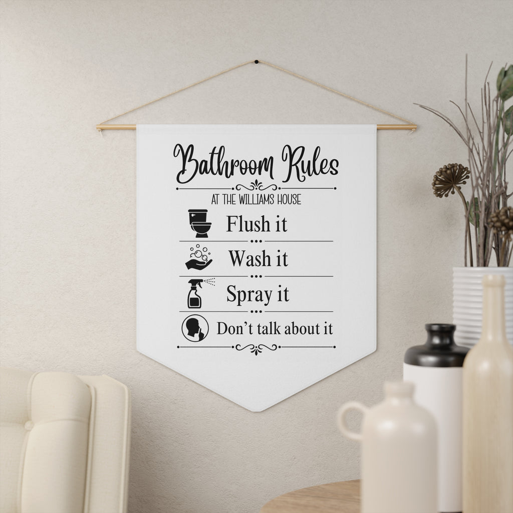 Funny Bathroom Rules pennant shown hanging on a wall as bathroom decor