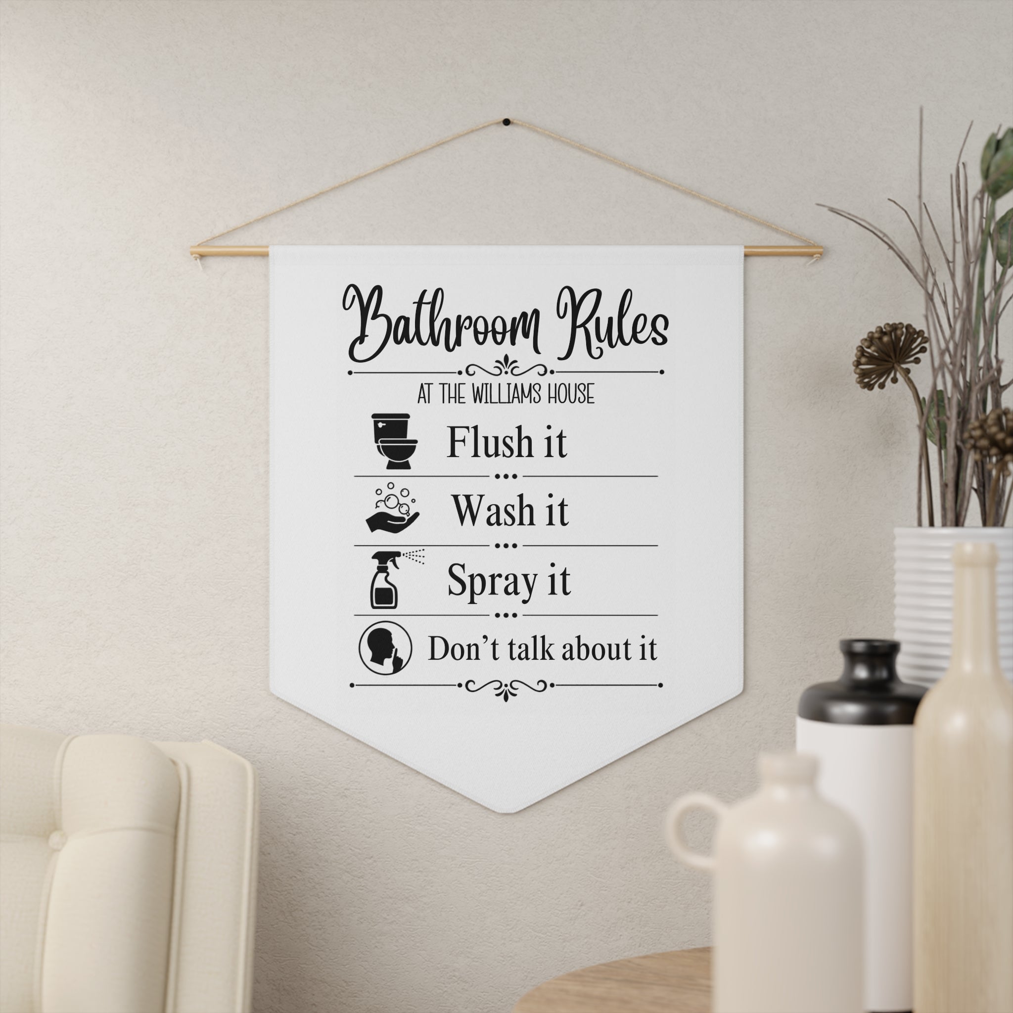 Funny Bathroom Rules pennant shown hanging on a wall as bathroom decor