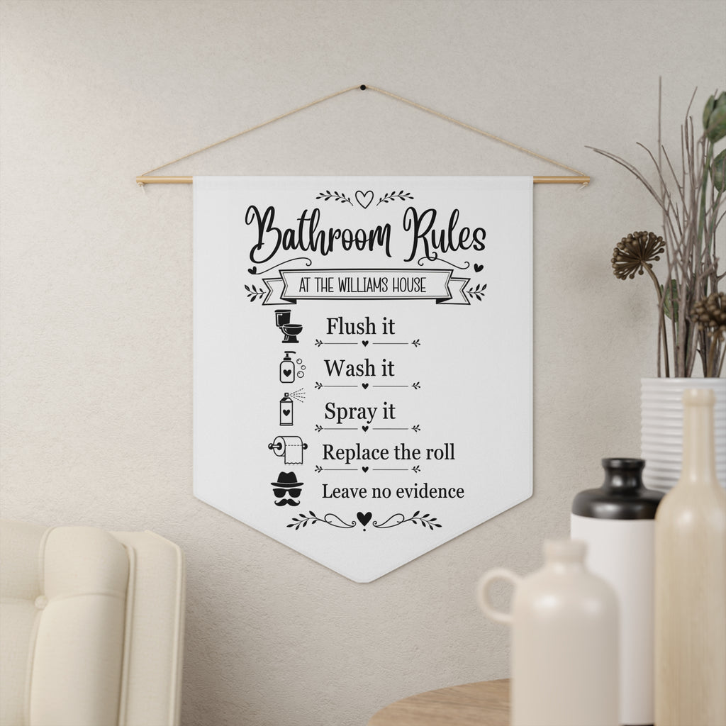Bathroom Rules pennant shown hanging on a wall as funny bathroom decor