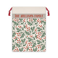 Personalized holly berry Santa sack with a family name band, green foliage and red berries on a cream drawstring bag