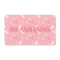 Personalized pink Christmas doormat with a family name, blush mittens, ornaments and snowflakes