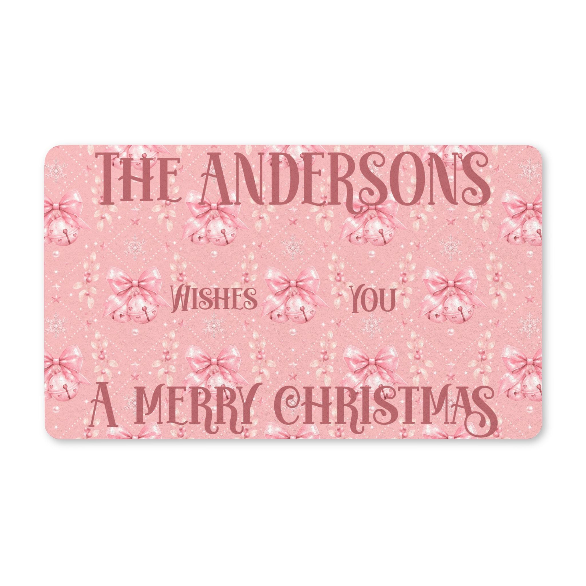 Personalized pink Merry Christmas doormat with a family name greeting, pink bells and bows