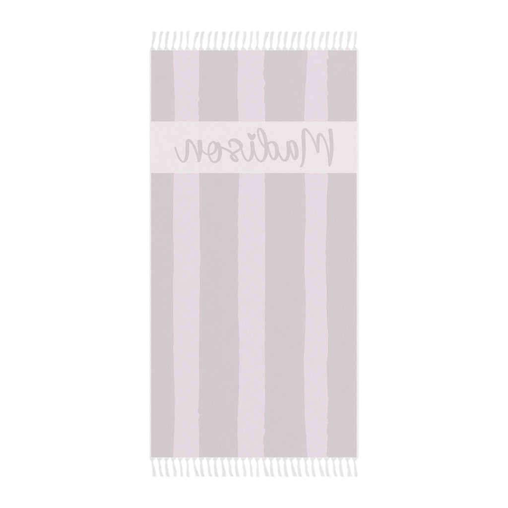 Personalized pink stripe beach towel laid flat with boho tassels