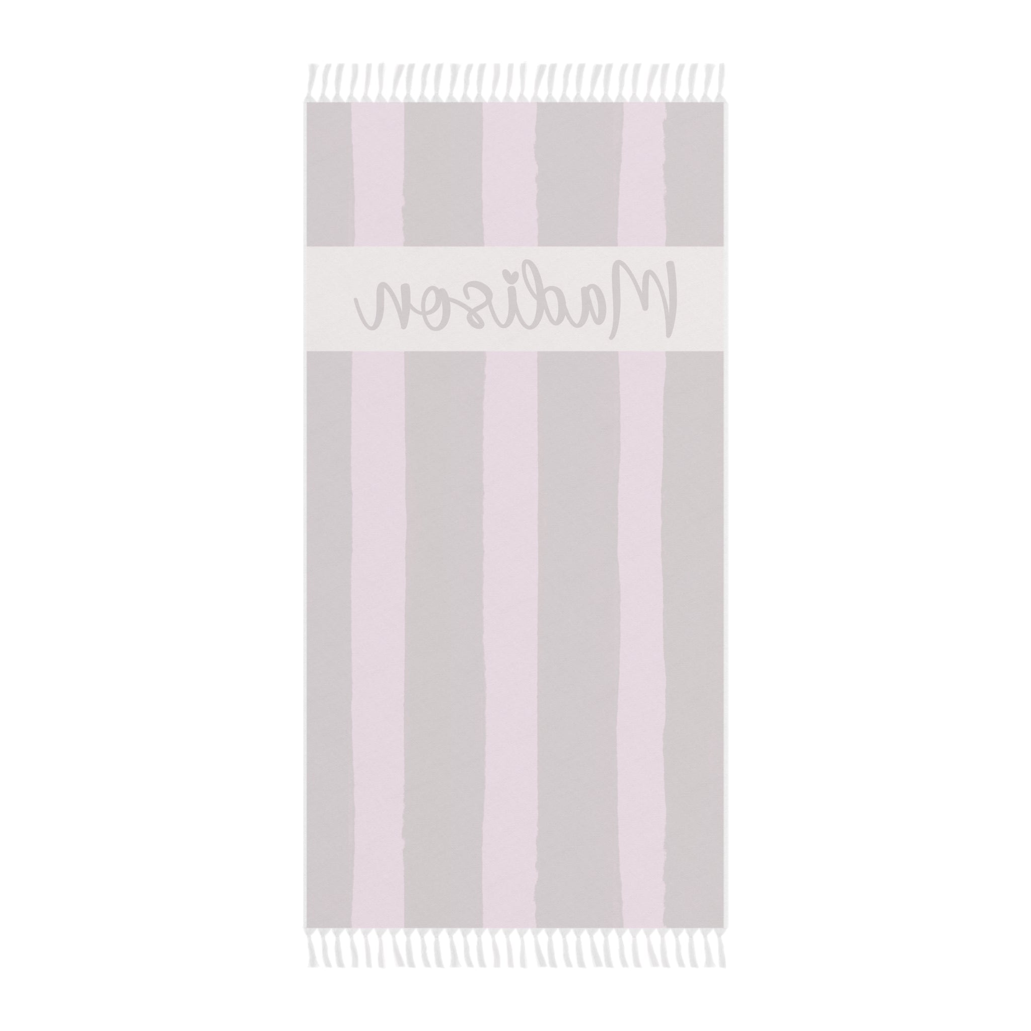 Personalized pink stripe beach towel laid flat with boho tassels