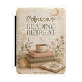 Personalized sage reading retreat Kindle case in soft neutral tones with books, a warm cup, and a custom name reading Reading Retreat