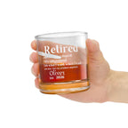 Hand holding a personalized 'Retired' definition whiskey rocks glass filled with whiskey