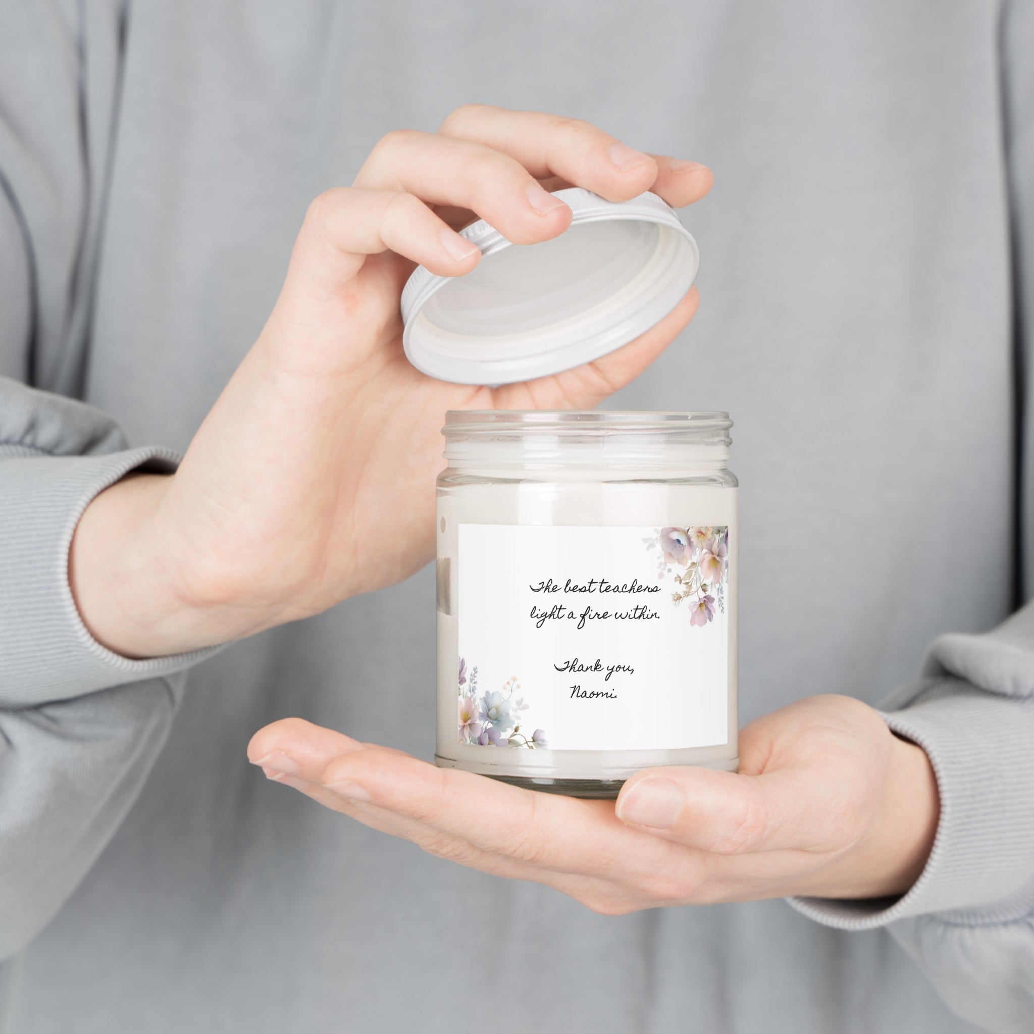 Personalized teacher appreciation candle held in hand to show its size